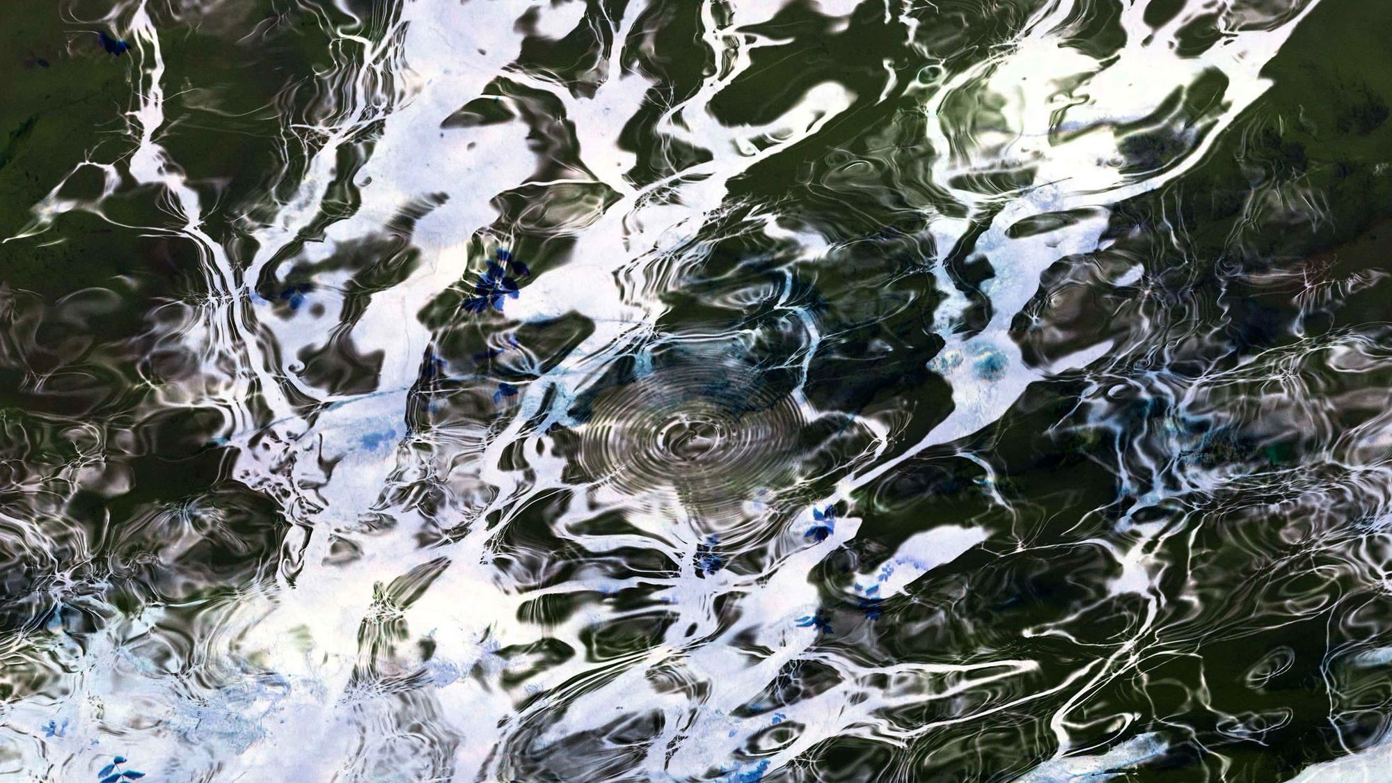 Das Bild zeigt eine abstrakte Spiegelung auf einer Wasserfläche.