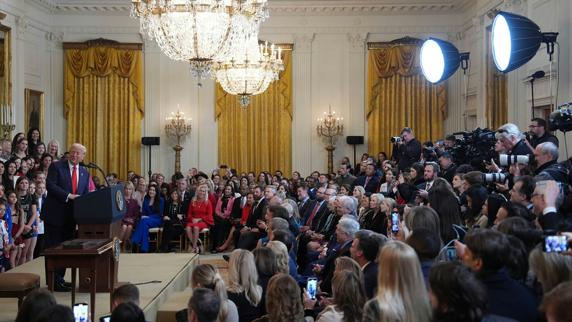 Donald Trump, umringt von Menschen, bei einer Rede im Weißen Haus.