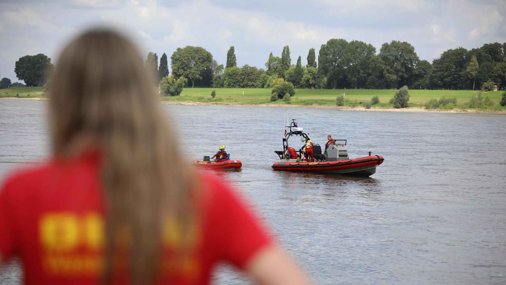 Ein Mitglied der Deutschen-Lebens-Rettungs-Gesellschaft (DLRG) beobachtet eine Rettungsübung auf dem Rhein.