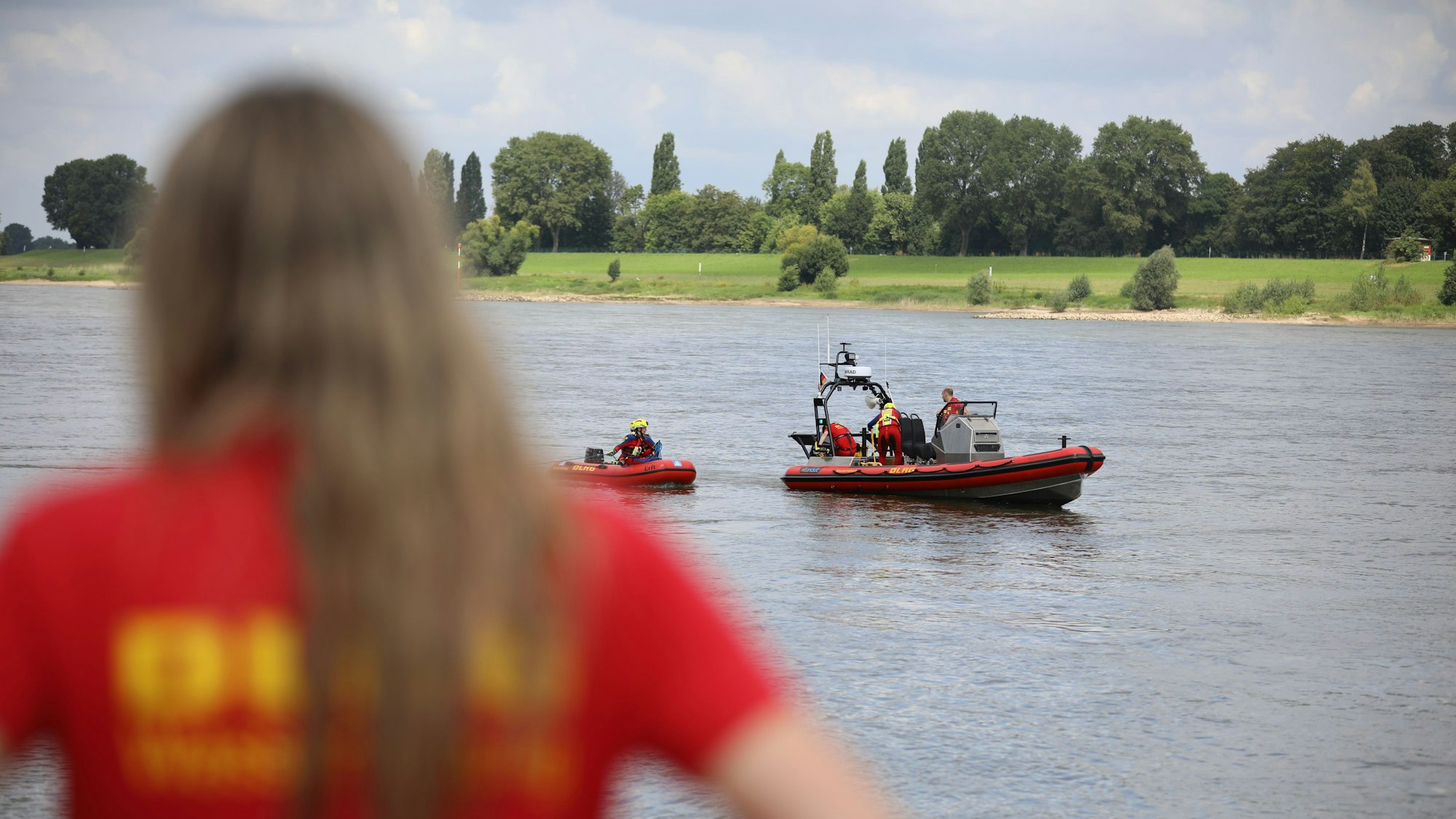 Ein Mitglied der Deutschen-Lebens-Rettungs-Gesellschaft (DLRG) beobachtet eine Rettungsübung auf dem Rhein.
