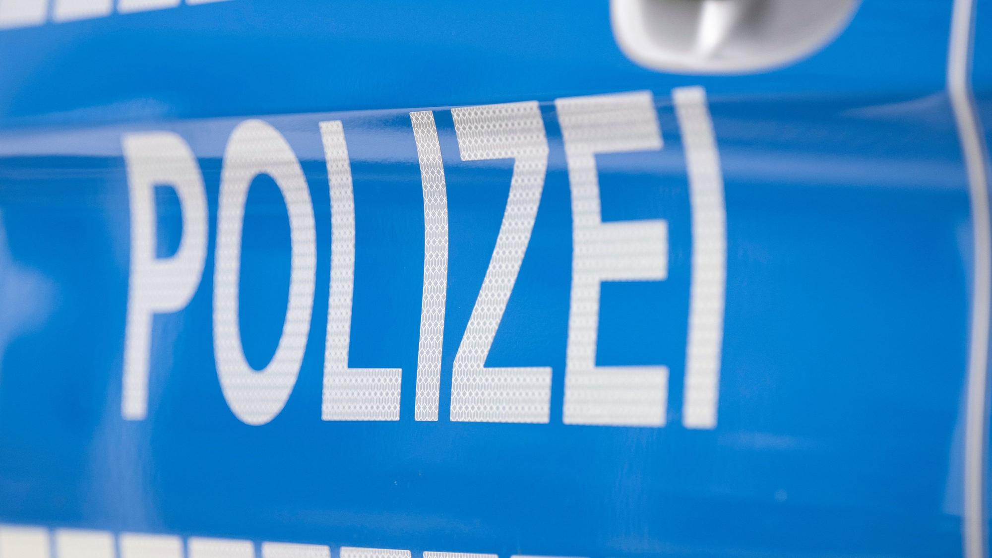 Auf einem Streifenwagen steht der Schriftzug „Polizei“.