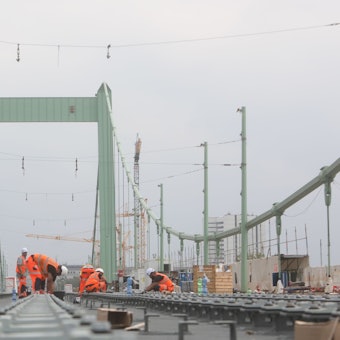Bauarbeiter arbeiten auf den Gleisen der Mülheimer Brücke.