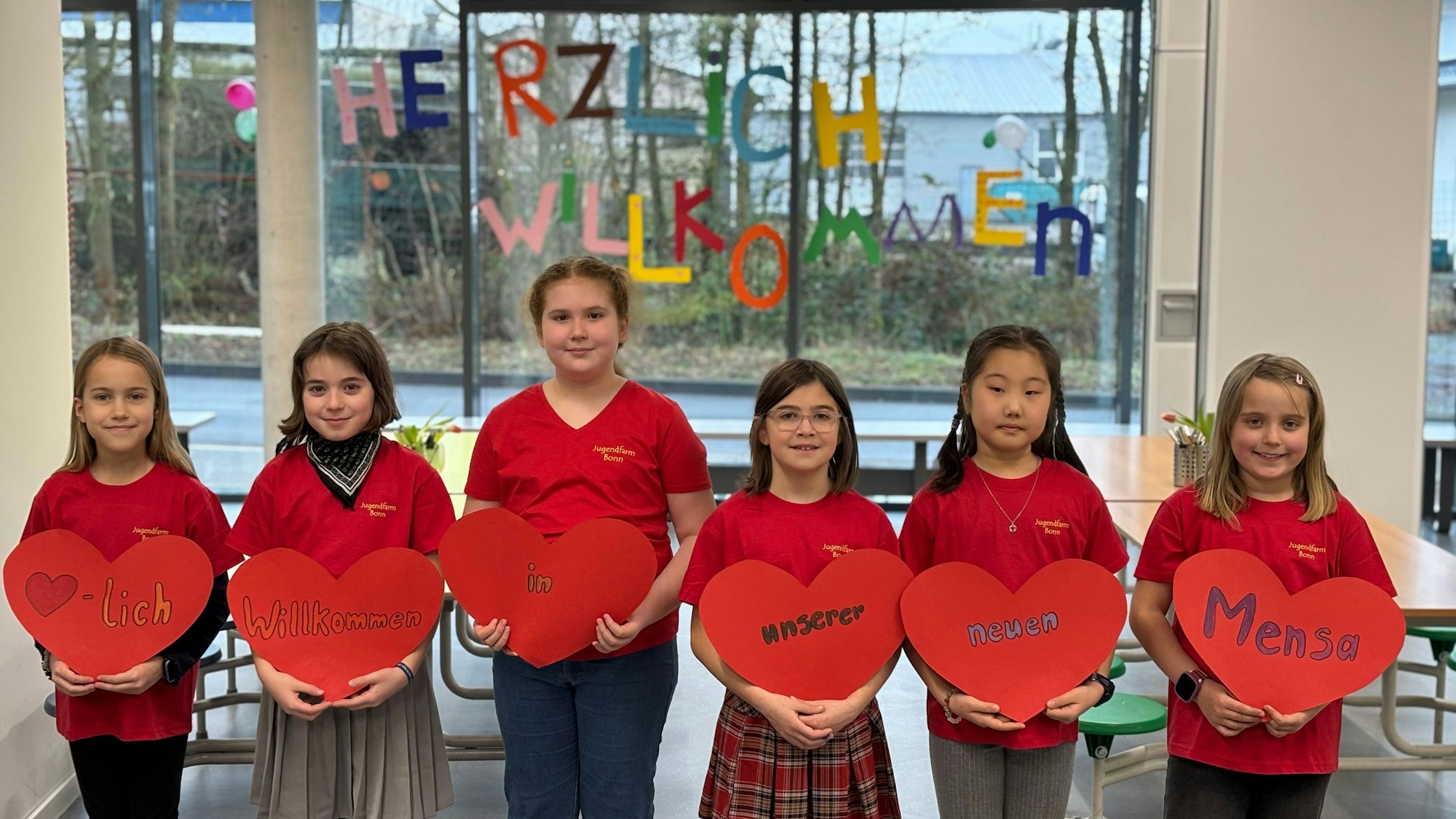 Sechs Mädchen halten herzförmige Pappen