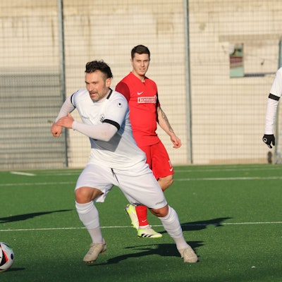 Athanasios Noutsos führt im Testspiel den Ball. Zwei Mitspieler und ein Gegenspieler schauen zu.