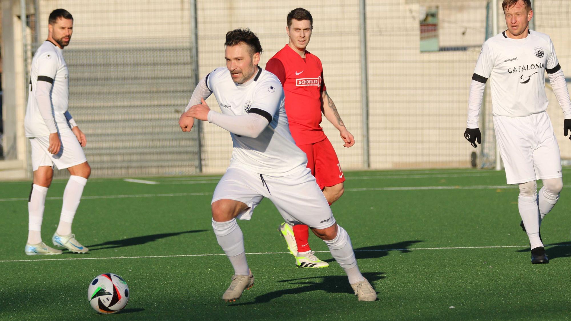 Athanasios Noutsos führt im Testspiel den Ball. Zwei Mitspieler und ein Gegenspieler schauen zu.