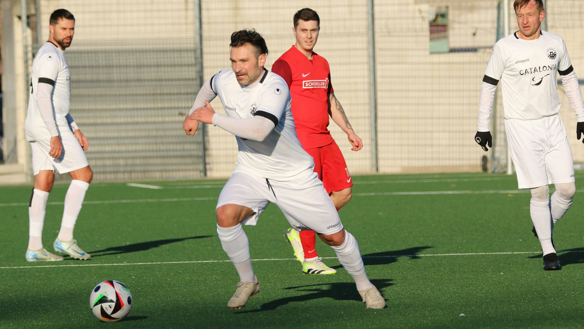 Athanasios Noutsos führt im Testspiel den Ball. Zwei Mitspieler und ein Gegenspieler schauen zu.