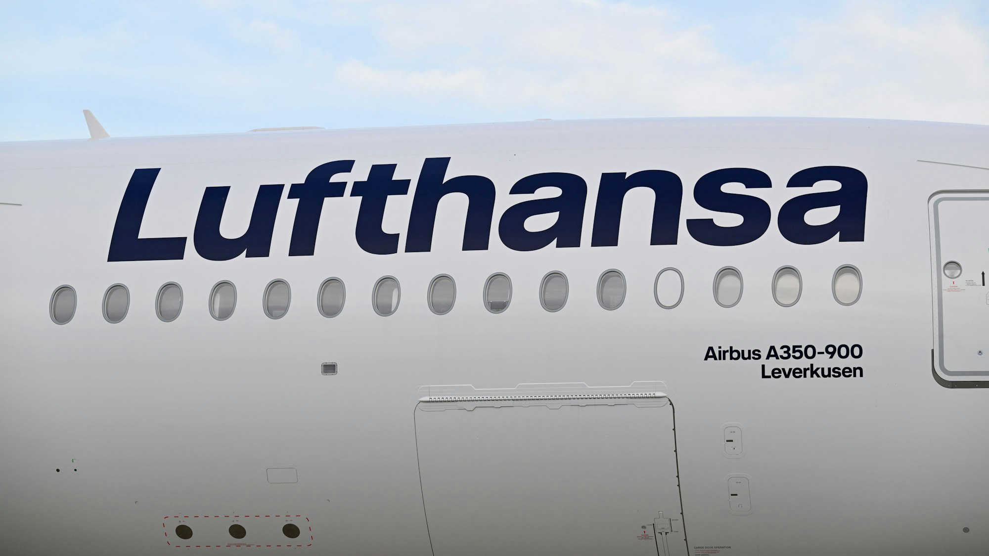 Außen rechts neben der vorderen Eingangstür steht der Name „Leverkusen“ auf einem Flugzeug.