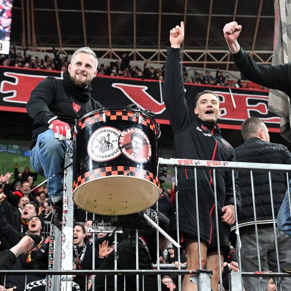 Florian Wirtz (M.) feiert mit den Leverkusener Ultras auf dem Zaun.