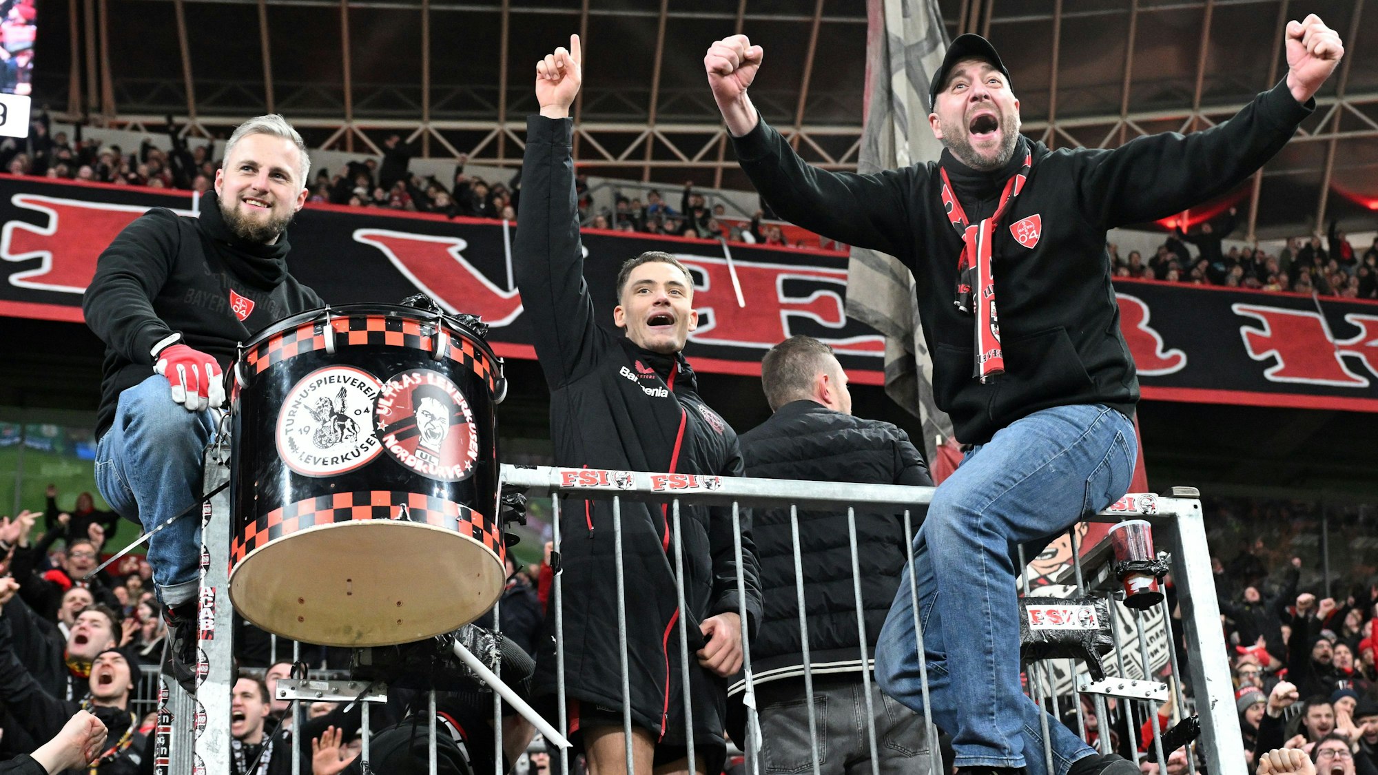Florian Wirtz (M.) feiert mit den Leverkusener Ultras auf dem Zaun.