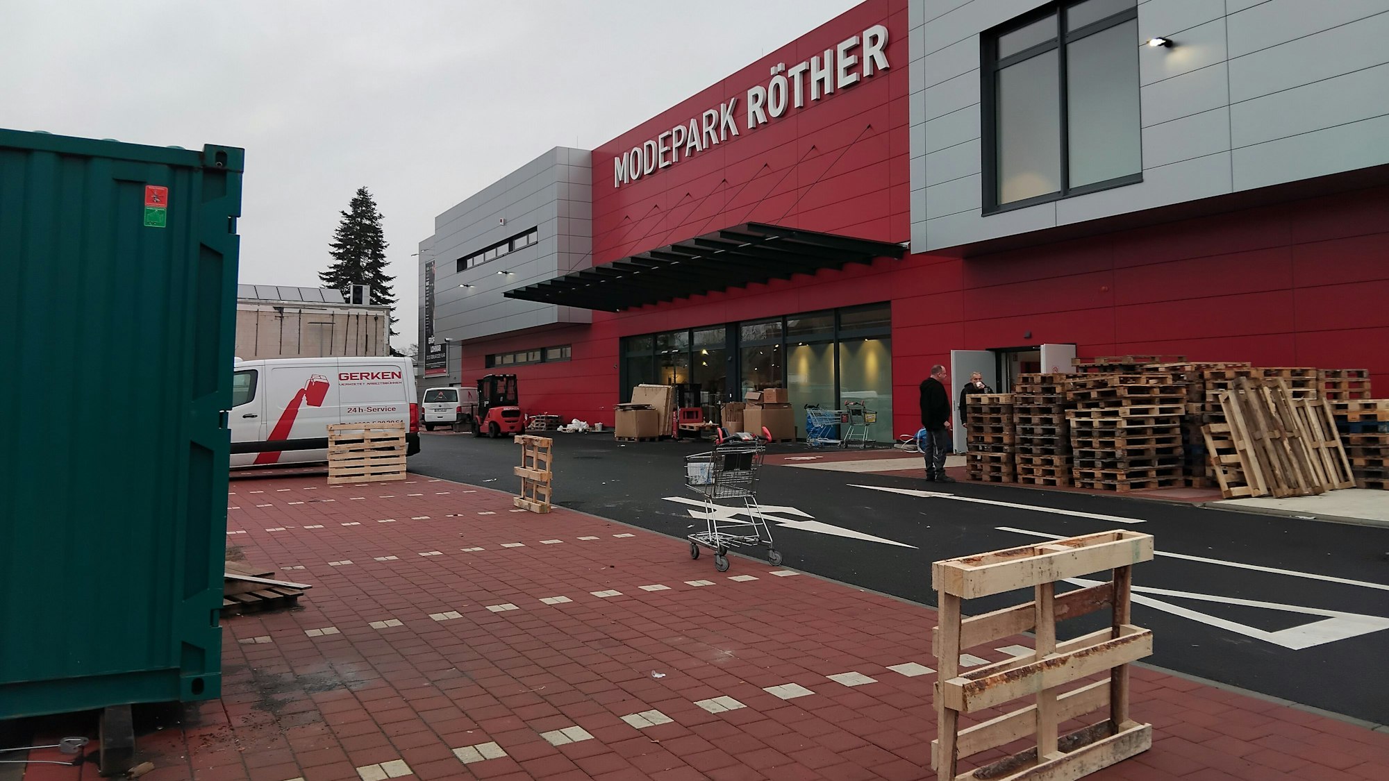 Der Eingang des Modeparks, davor Paletten und Container