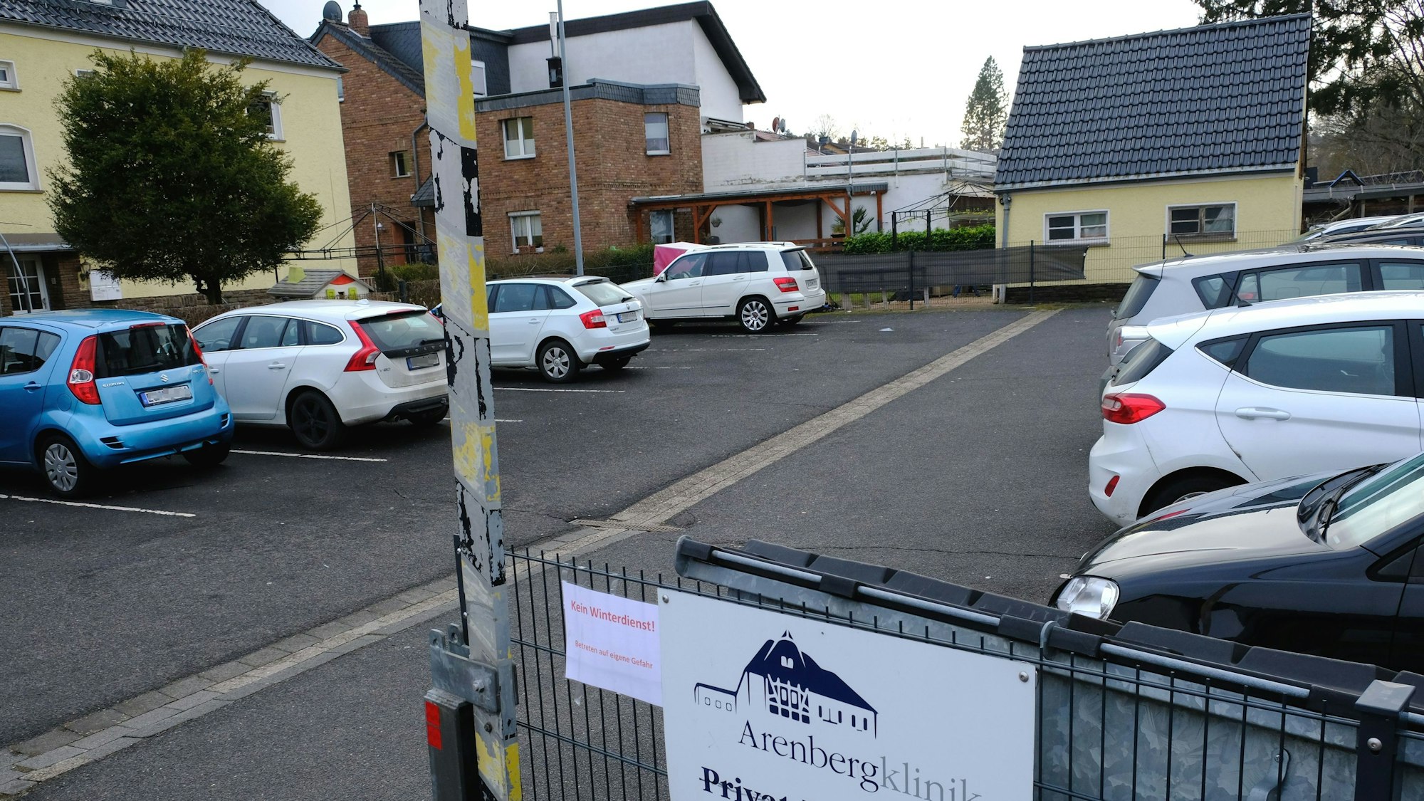 Auf einem Parkplatz an der Arembergstraße stehen zahlreiche Fahrzeuge.