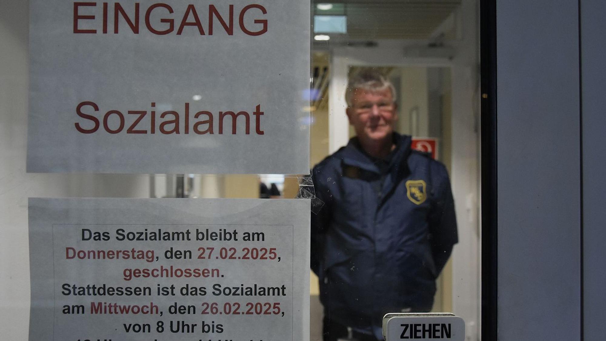 Das Foto zeigt einen Mitarbeiter eines Sicherheitsdienstes an der Tür des Sozialamtes.