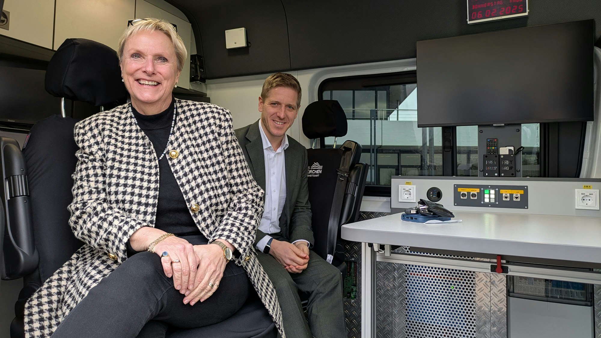Geschäftsbereichsleiterin Birgit Wonneberger-Wrede und Landrat Markus haben im mobilen Gesundheitsamt Platz genommen.