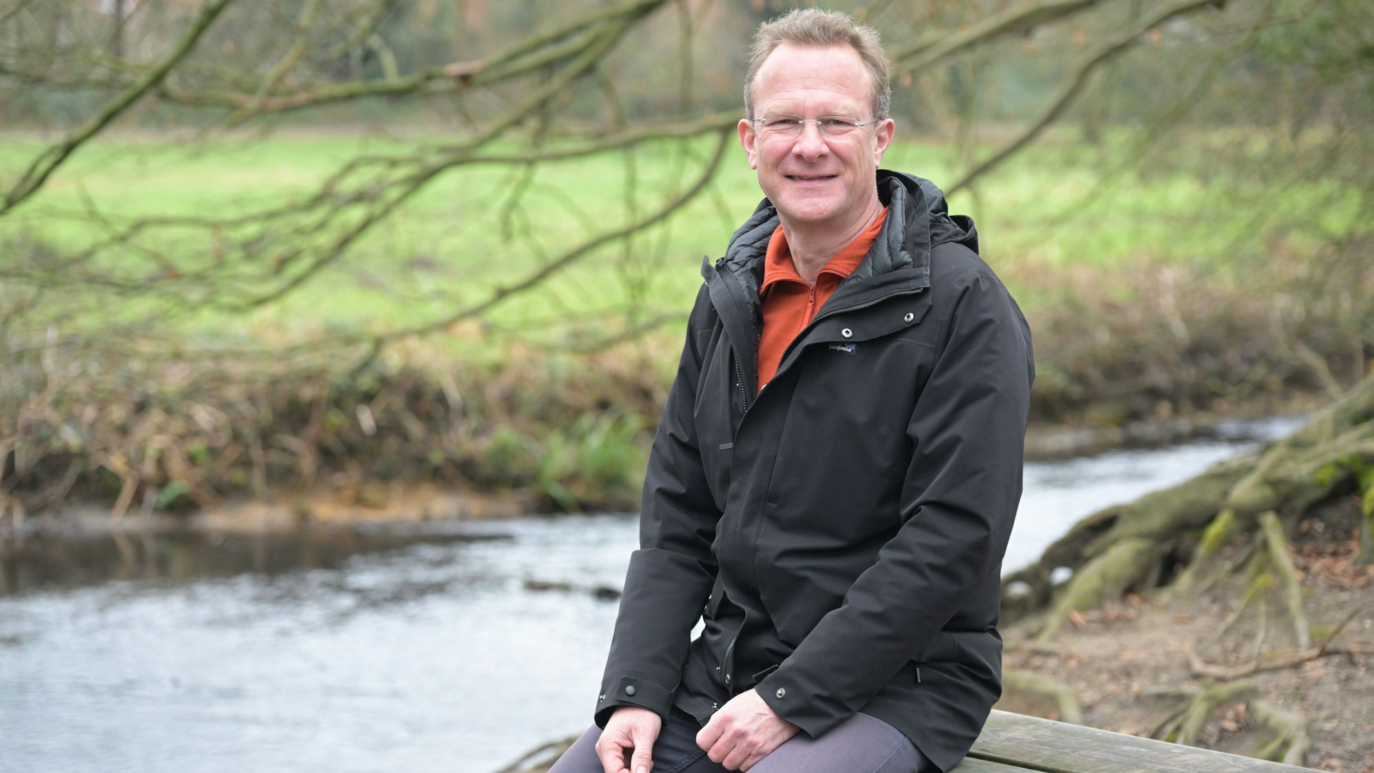 Maik Außendorf sitzt auf einer Bank am Mutzbach.