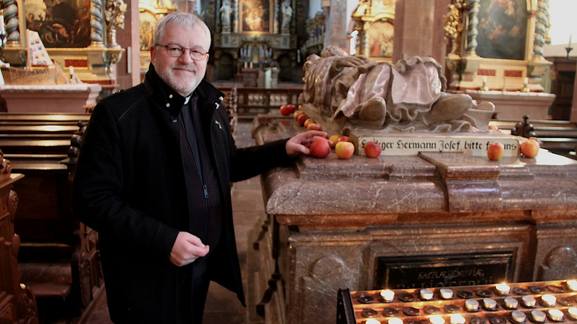 Wieslaw Kaczor steht am Sarkophag des Hl. Hermann-Josef von Steinfeld in der Basilika.