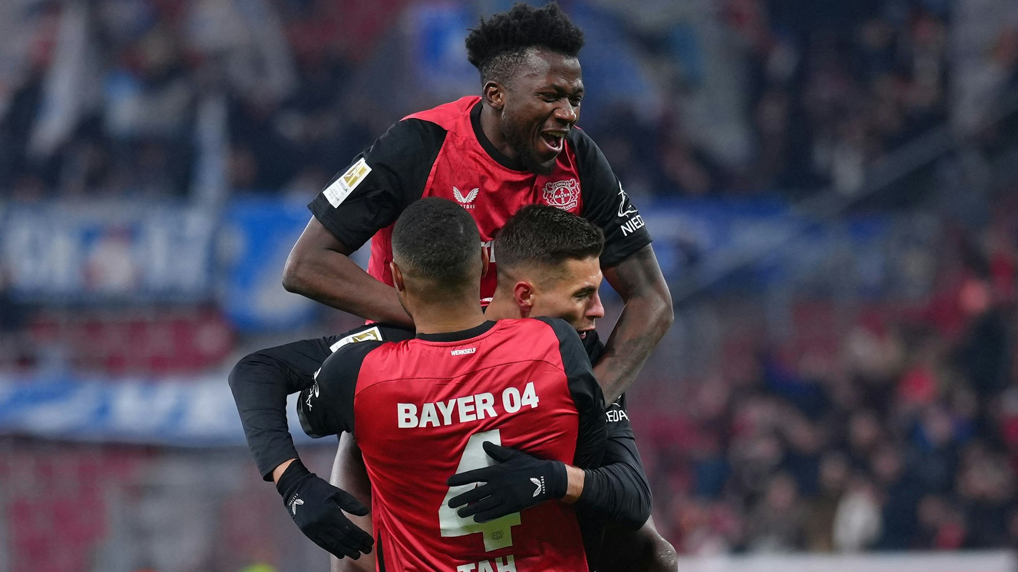 Bayer Leverkusen's Czech forward #14 Patrik Schick (C) is celebrated by team mates Bayer Leverkusen's German defender #04 Jonathan Tah (front) and Bayer Leverkusen's Burkinabe defender #12 Edmond Tapsoba (top) after scoring the 3-0 goal during the German first division Bundesliga football match Bayer 04 Leverkusen v TSG 1899 Hoffenheim in Leverkusen, western Germany on February 2, 2025. (Photo by Pau BARRENA / AFP) / DFL REGULATIONS PROHIBIT ANY USE OF PHOTOGRAPHS AS IMAGE SEQUENCES AND/OR QUASI-VIDEO