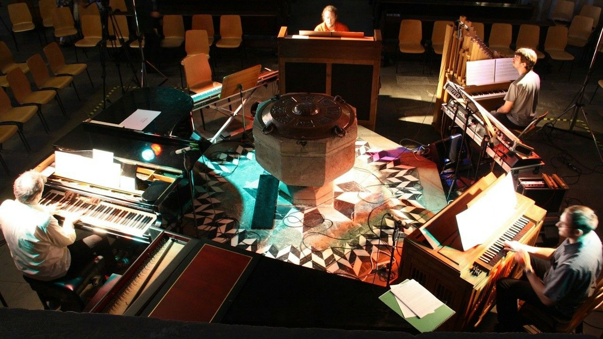 Vier Musiker spielen zeitgleich auf verschiedenen Tasteninstrumenten.