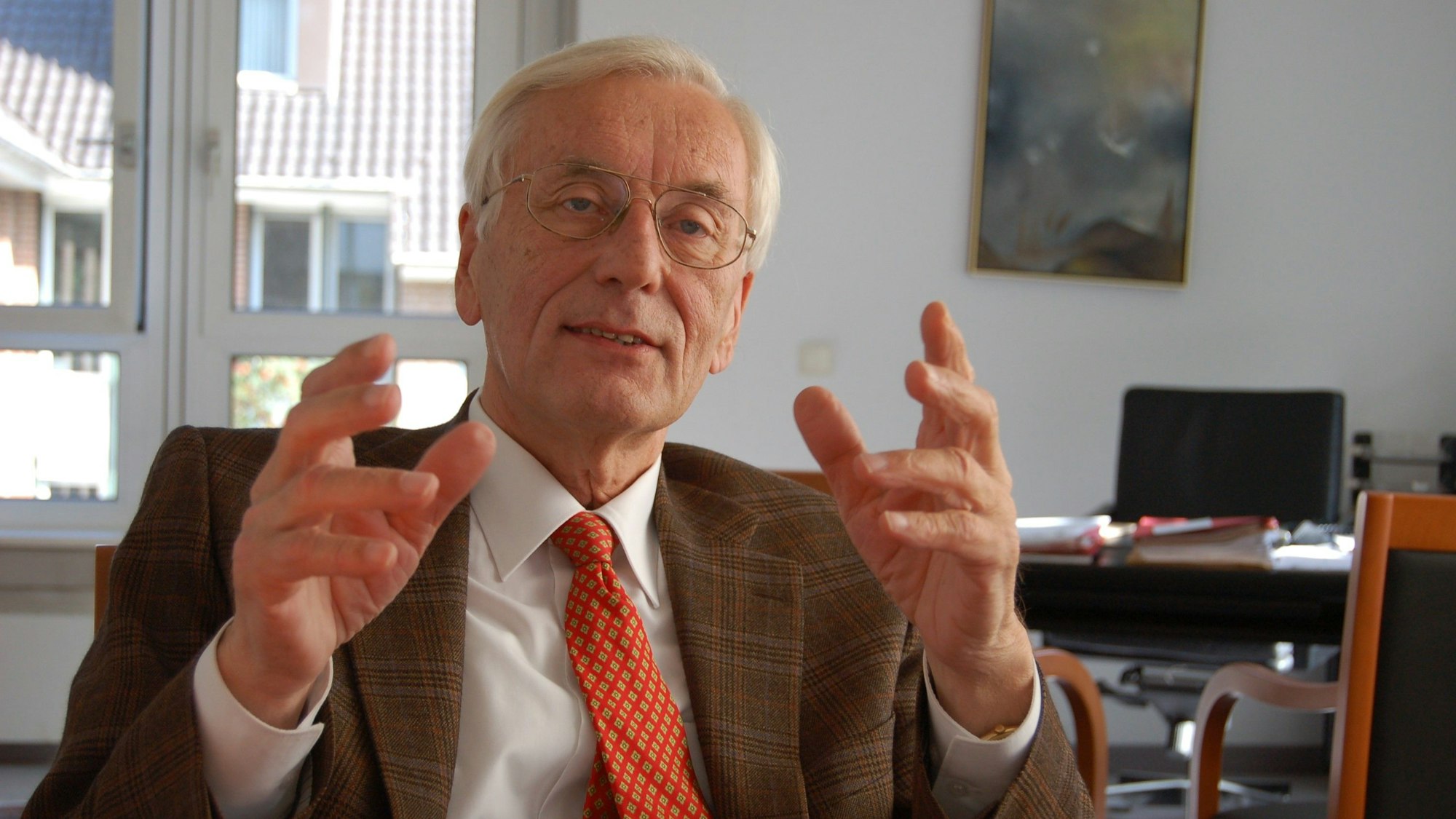 Ein Mann, er gestikuliert mit seinen Händen.