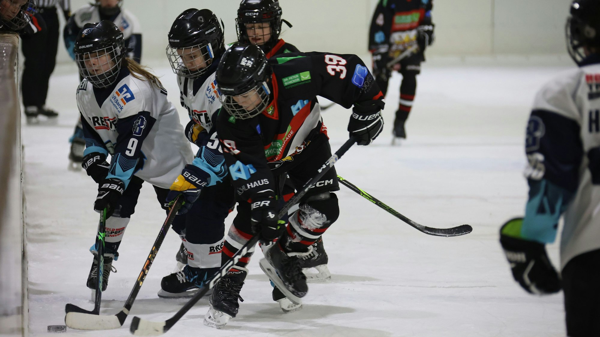 Der Eishockey-Spieler mit der 39 ist vor seinen Gegenspielern am Puck.