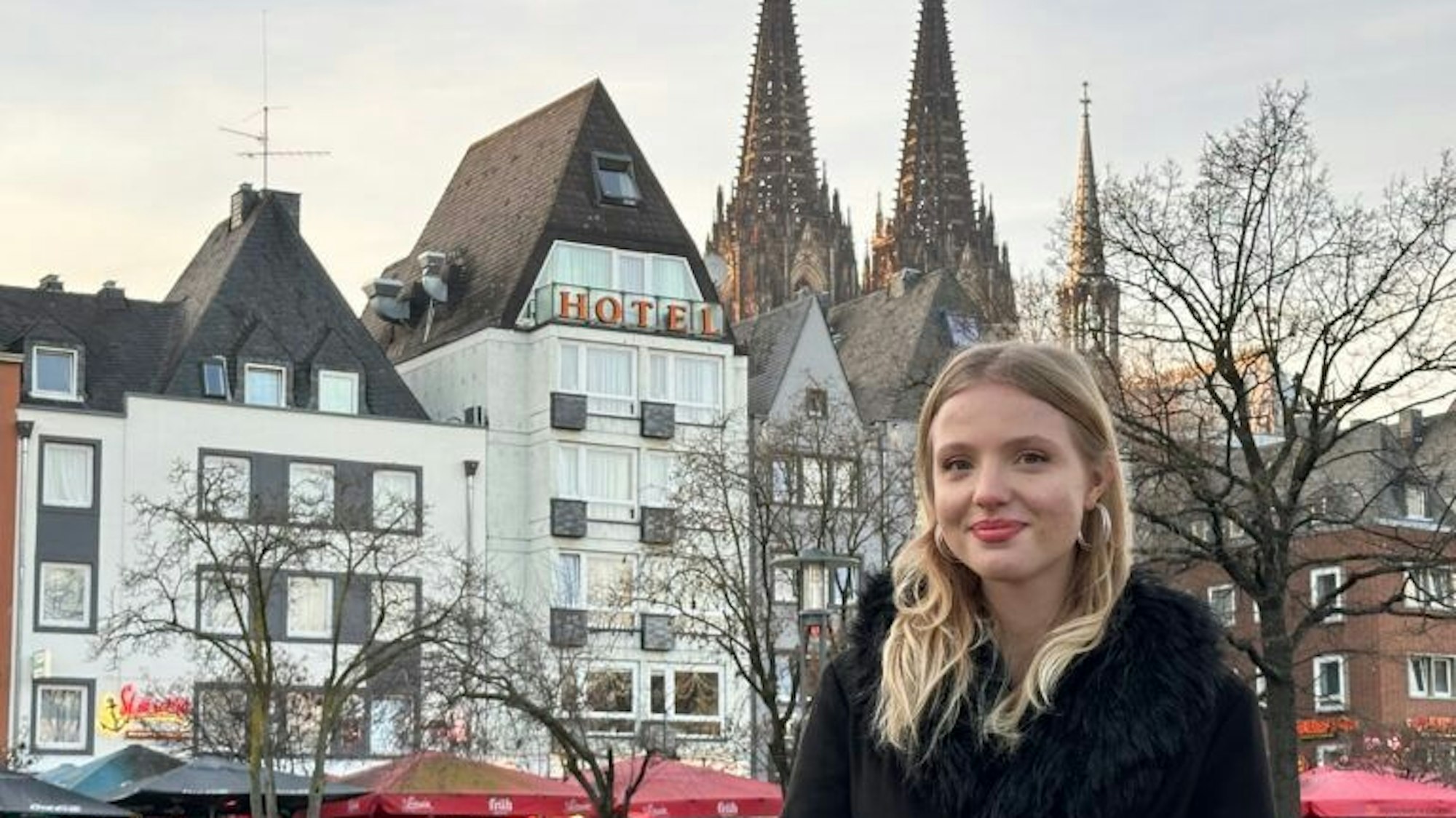 Kateryna Knaub ist Vorstandsmitglied der Bezirksschüler*innenvertretung und steht auf dem Foto in der Kölner Altstadt mit dem Dom im Hintergrund.