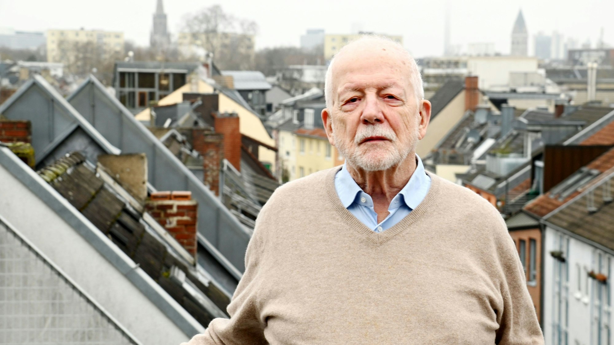 Fritz Scharpf ist auf einem Balkon über den Dächern von Köln zu sehen.