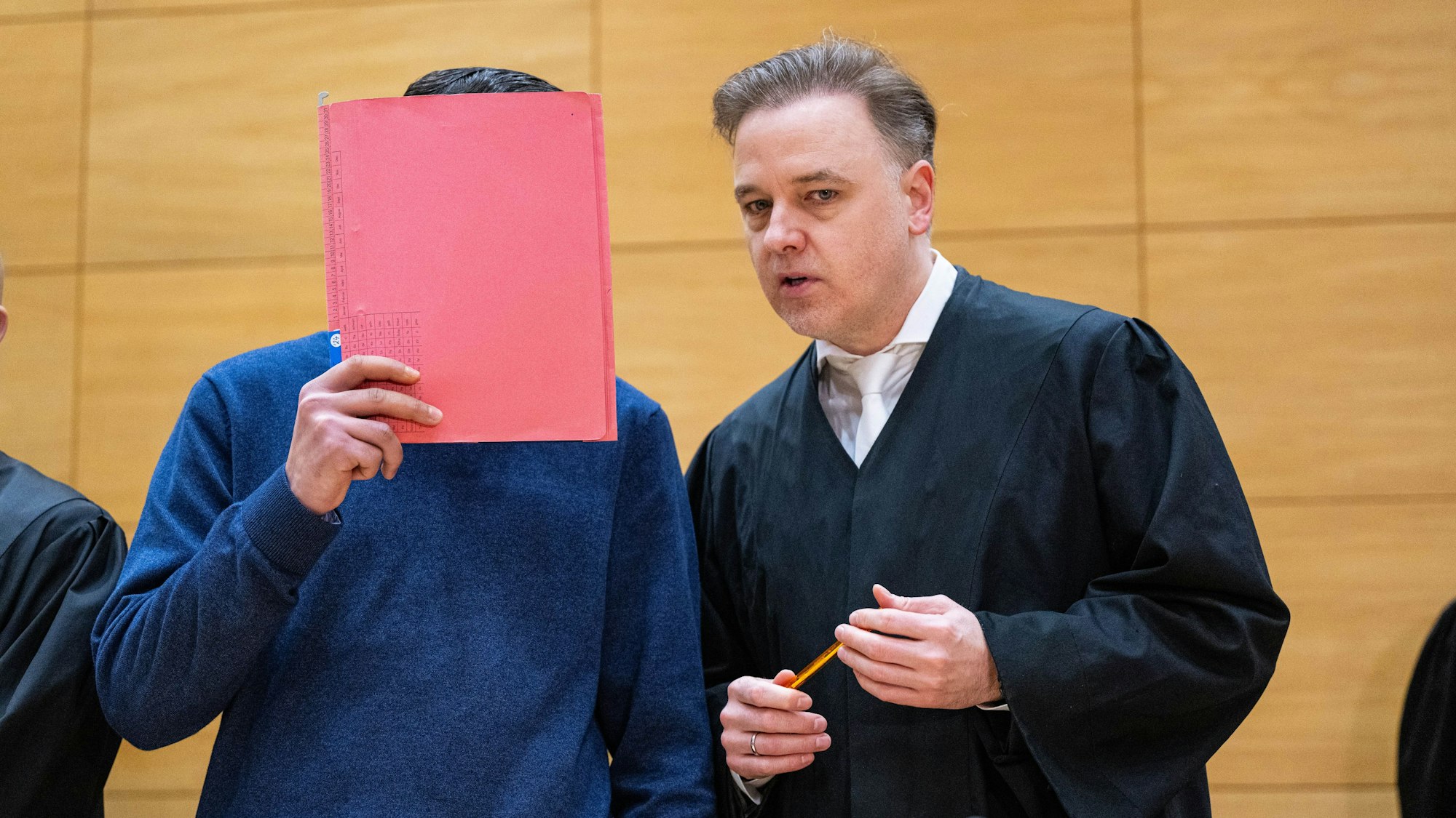 ARCHIV - 17.12.2024, Nordrhein-Westfalen, Bielefeld: Einer der Angeklagten (l.) steht mit seinem Anwalt Burkhard Benecken beim Beginn des Prozesses um den Totschlag nach einer Abifeier in Bad Oeynhausen vor dem Landgericht. Angeklagt sind drei Männer. (zu dpa: «Aussage angekündigt: Prozess um Tod nach Abifeier in Bad Oeynhausen») Foto: Guido Kirchner/dpa +++ dpa-Bildfunk +++