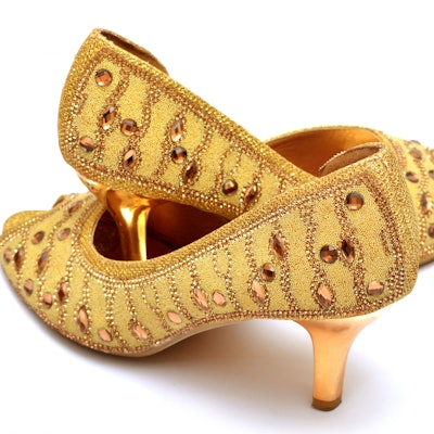 Golden lady shoes closeup isolated.
