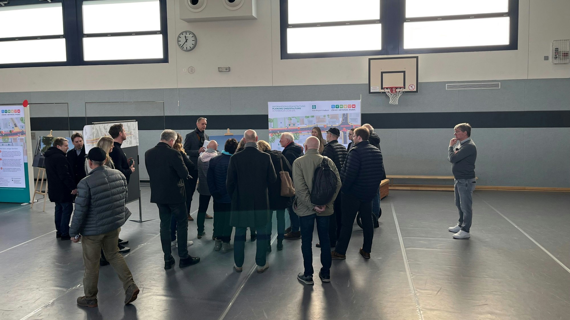 Eine kleine Gruppe von Besuchern steht vor einer Stellwand.