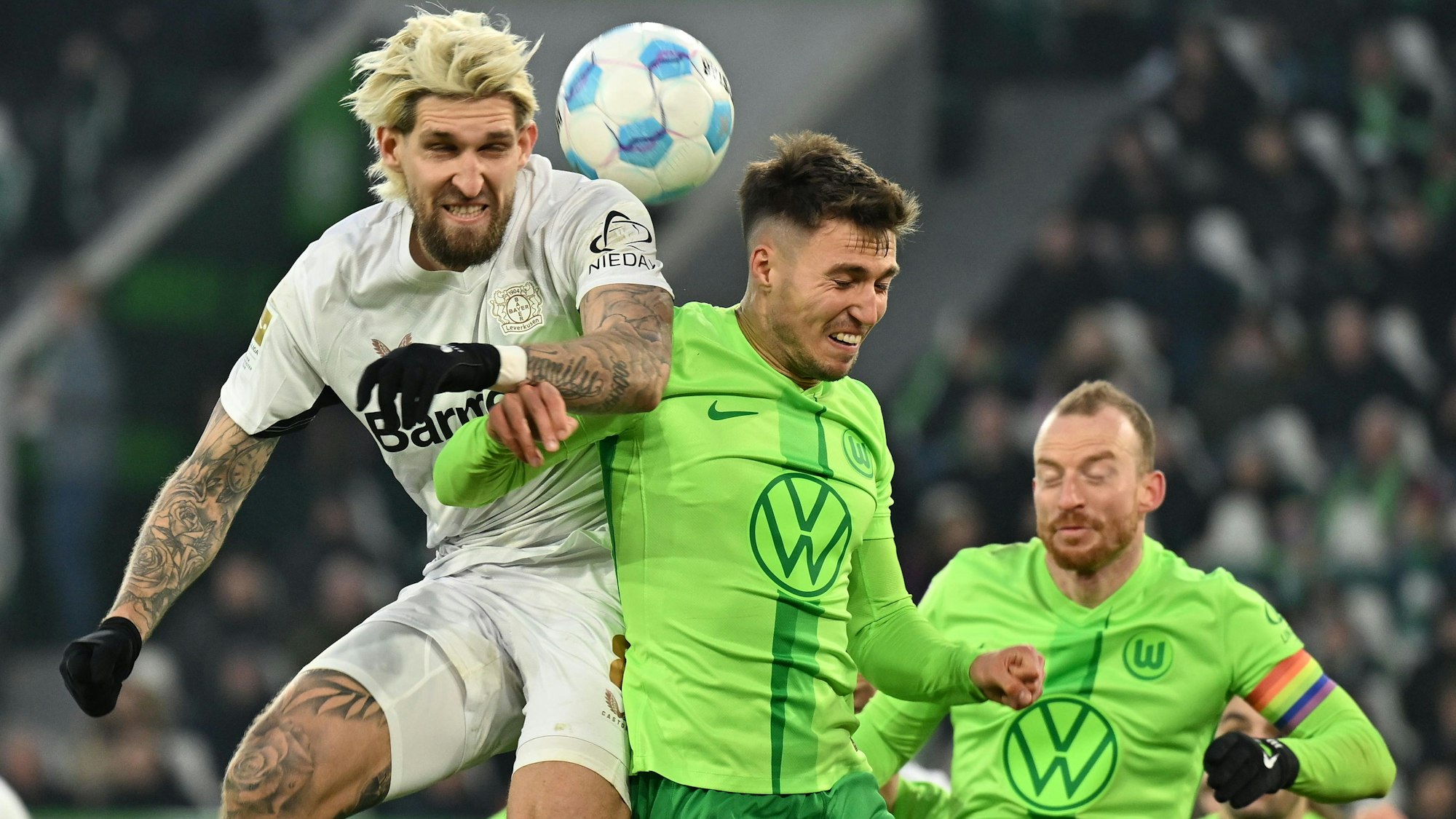 08.02.2025, Niedersachsen, Wolfsburg: Fußball: Bundesliga, VfL Wolfsburg - Bayer Leverkusen, 21. Spieltag, Volkswagen Arena. Leverkusens Robert Andrich (l) spielt gegen Wolfsburgs Kilian Fischer und Wolfsburgs Maximilian Arnold (r). Foto: Swen Pförtner/dpa - WICHTIGER HINWEIS: Gemäß den Vorgaben der DFL Deutsche Fußball Liga bzw. des DFB Deutscher Fußball-Bund ist es untersagt, in dem Stadion und/oder vom Spiel angefertigte Fotoaufnahmen in Form von Sequenzbildern und/oder videoähnlichen Fotostrecken zu verwerten bzw. verwerten zu lassen. +++ dpa-Bildfunk +++