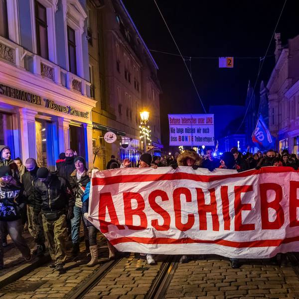 Demonstranten in Cottbus laufen mit einem Plakat «Abschieben» durch die Innenstadt.