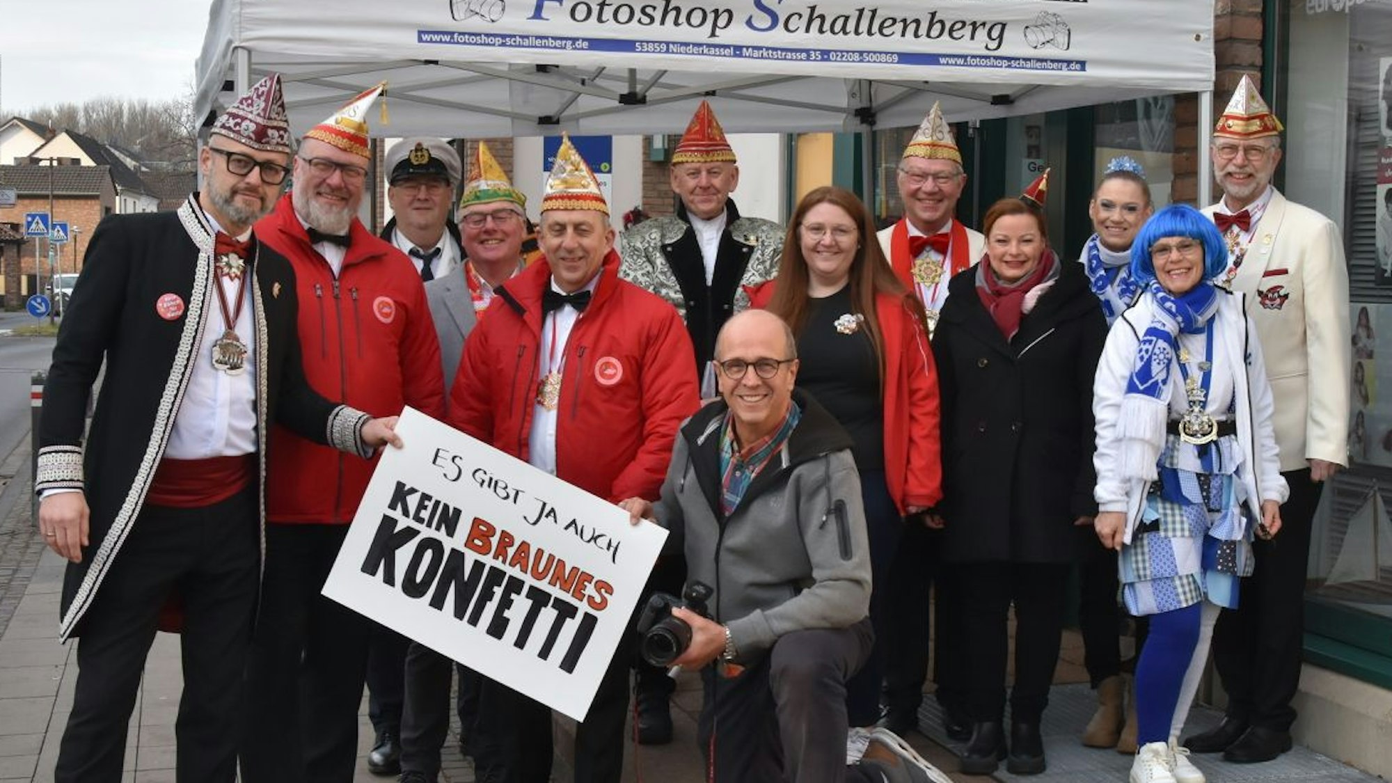 Vertreter mehrerer Troisdorfer Karnevalsgesellschaften zeigen sich nach dem Fotoshooting mit einem Plakat.