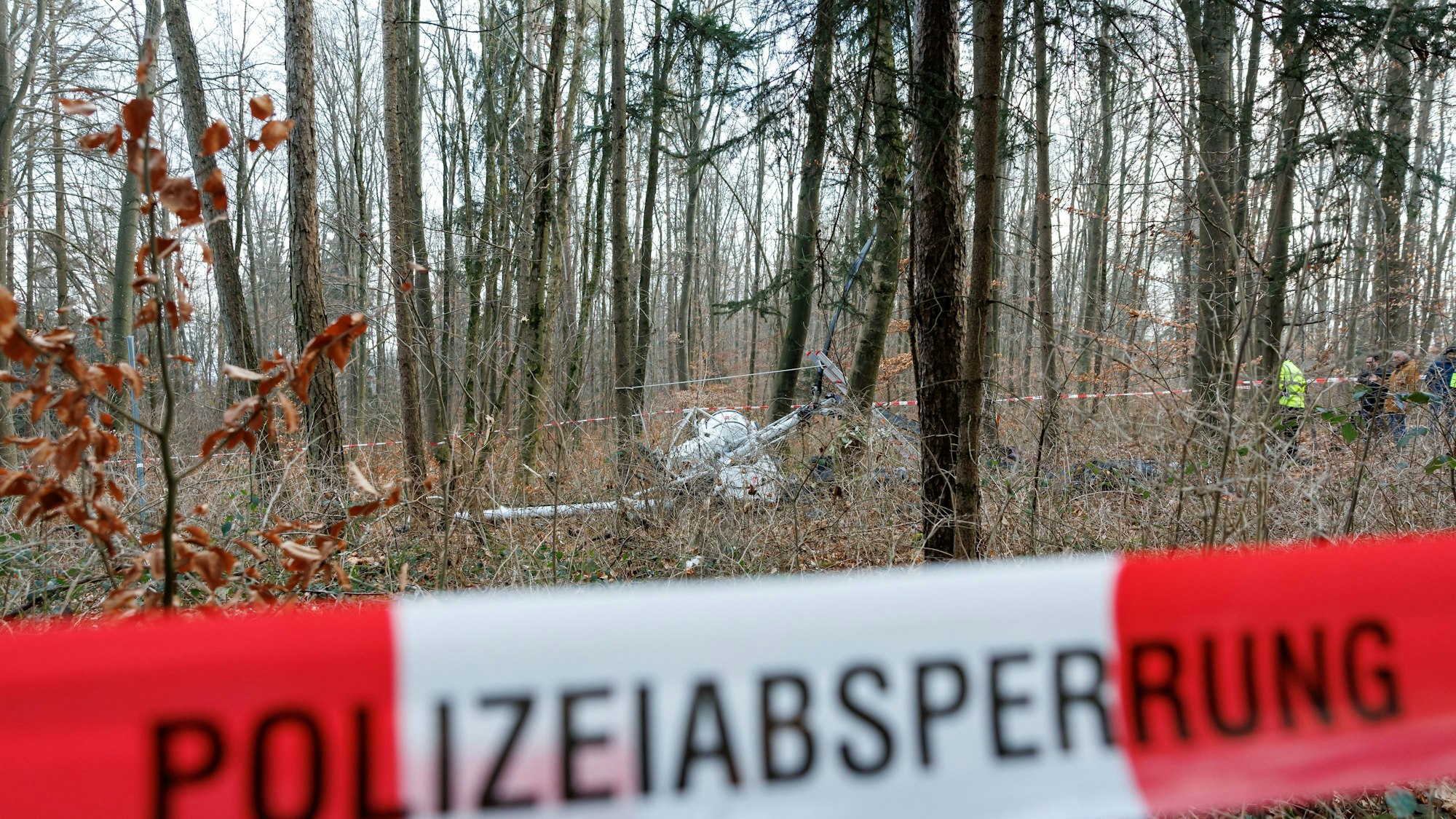 Ein abgestürzter Hubschrauber liegt in einem Wald.