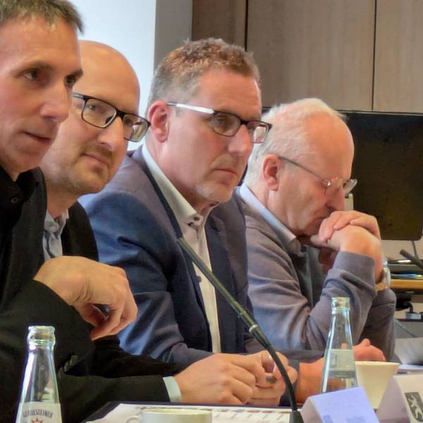 Marcel Wolter, Ingo Pfennings, Norbert Crump und Dr. Hans-Peter Schick sitzen am Tisch und blicken ernst.