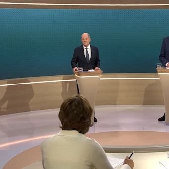 SCREENSHOT - 09.02.2025, Berlin: Bundeskanzler Olaf Scholz (SPD, l), steht neben Friedrich Merz, Unions Kanzlerkandidat und CDU Bundesvorsitzender, während dem TV-Duell von ARD und ZDF (Screenshot). In 90 Minuten stellen sich beide im Studio Berlin-Adlershof zentralen Fragen und debattieren zu den wesentlichen Themen des Bundestagswahlkampfs. Moderiert wird die Sendung von Sandra Maischberger (unten r, ARD) und Maybrit Illner (unten l, ZDF). Foto: ---/ARD/ZDF/dpa - ACHTUNG: Nur zur redaktionellen Verwendung im Zusammenhang mit einer Berichterstattung über die Sendung TV Duell 2025 und nur mit vollständiger Nennung des vorstehenden Credits +++ dpa-Bildfunk +++
