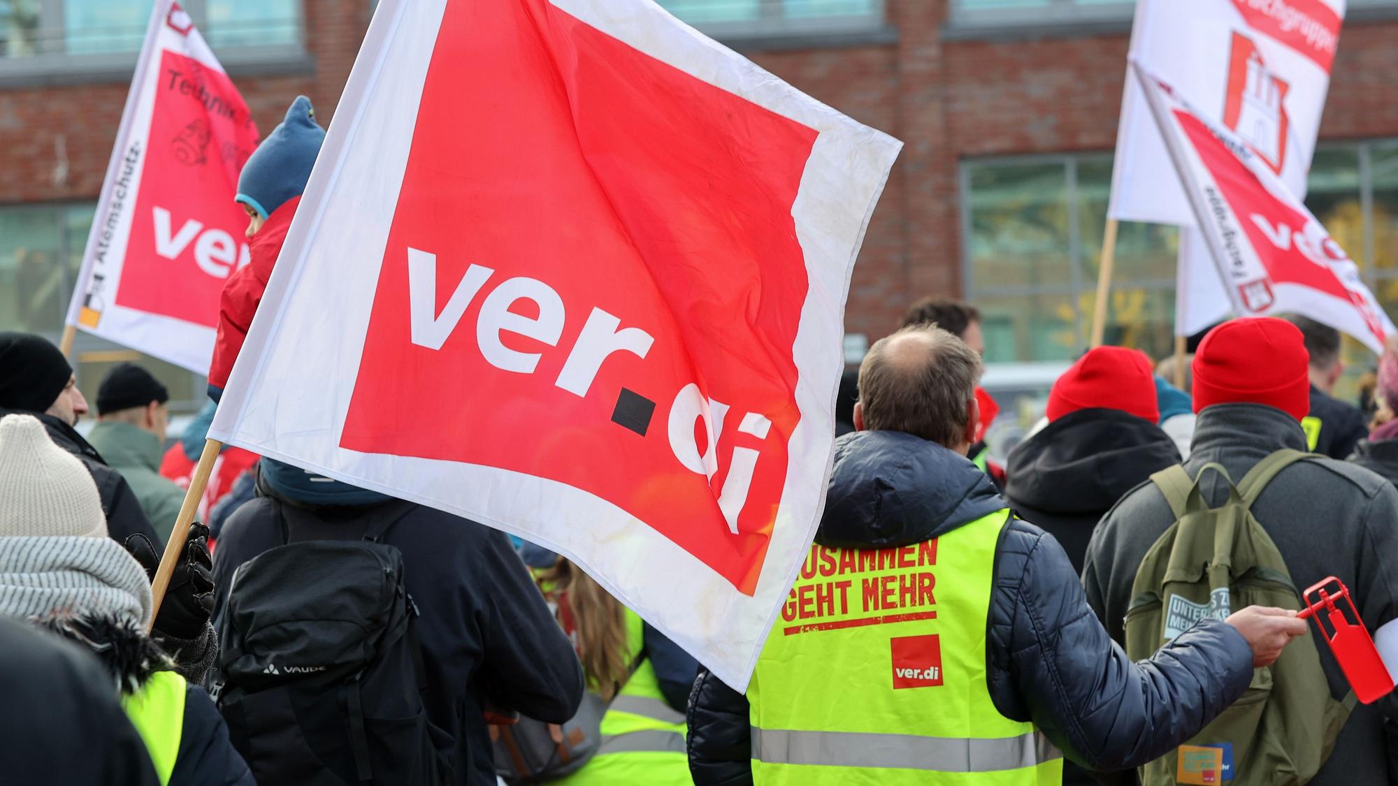 ARCHIV - 13.11.2023, Hamburg: Mit Verdi-Fahnen demonstrieren Teilnehmer in Hamburg-Bergedorf während eines Warnstreiks. (zu dpa: «Verdi ruft zu zentralem Warnstreiktag in Hamburg auf») Foto: Bodo Marks/dpa +++ dpa-Bildfunk +++