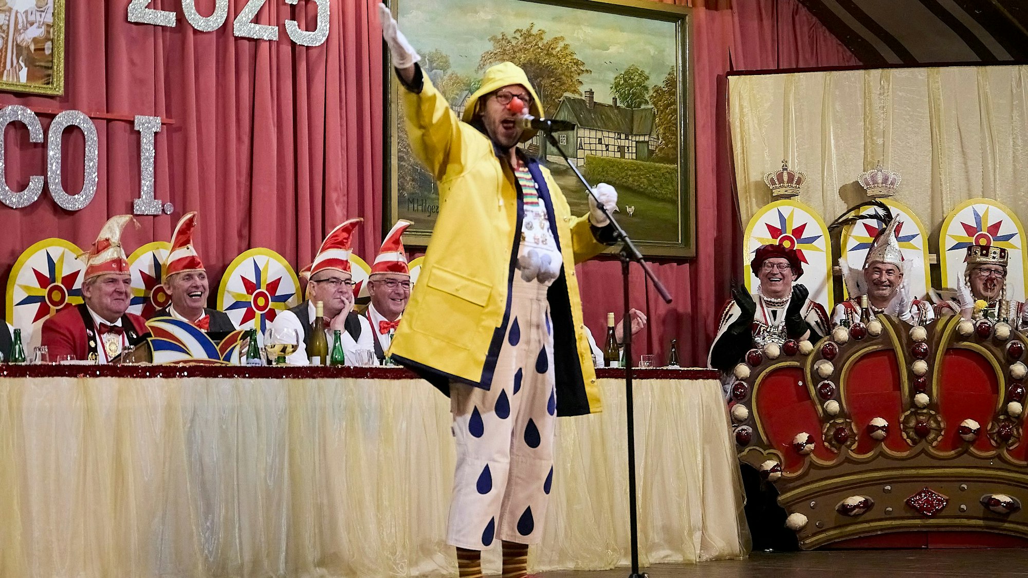 Redner Björn Wassong, mit roter Pappnase, gelber Regenjacke und passendem Südwester, unterhielt als „Jeck em Rähn“ das Publikum.