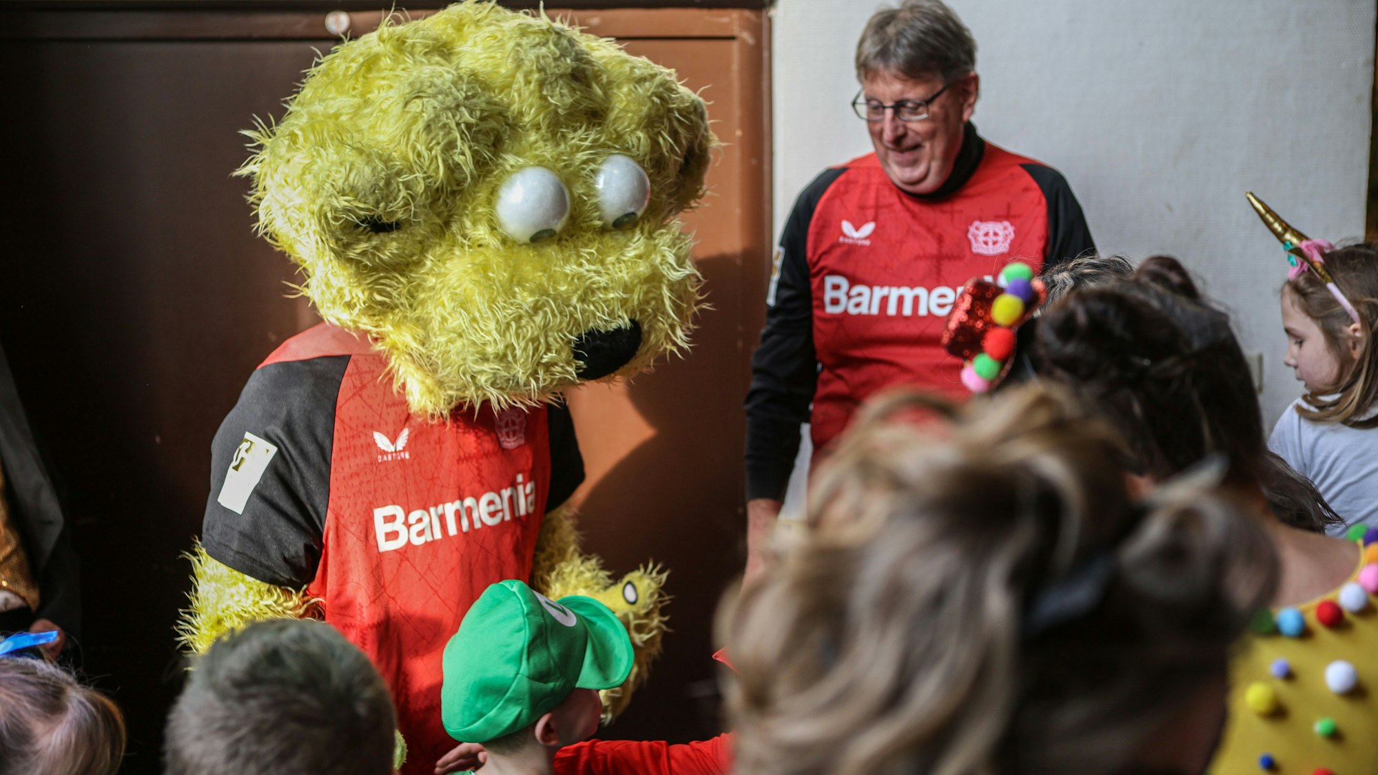 Maskottchen von Bayer 04 zwischen Kindern