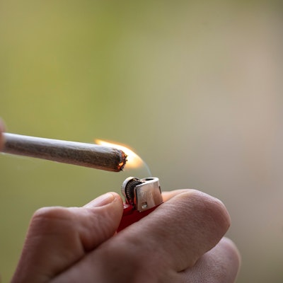 Ein Mann zündet sich einen Joint an. (Symbolbild)