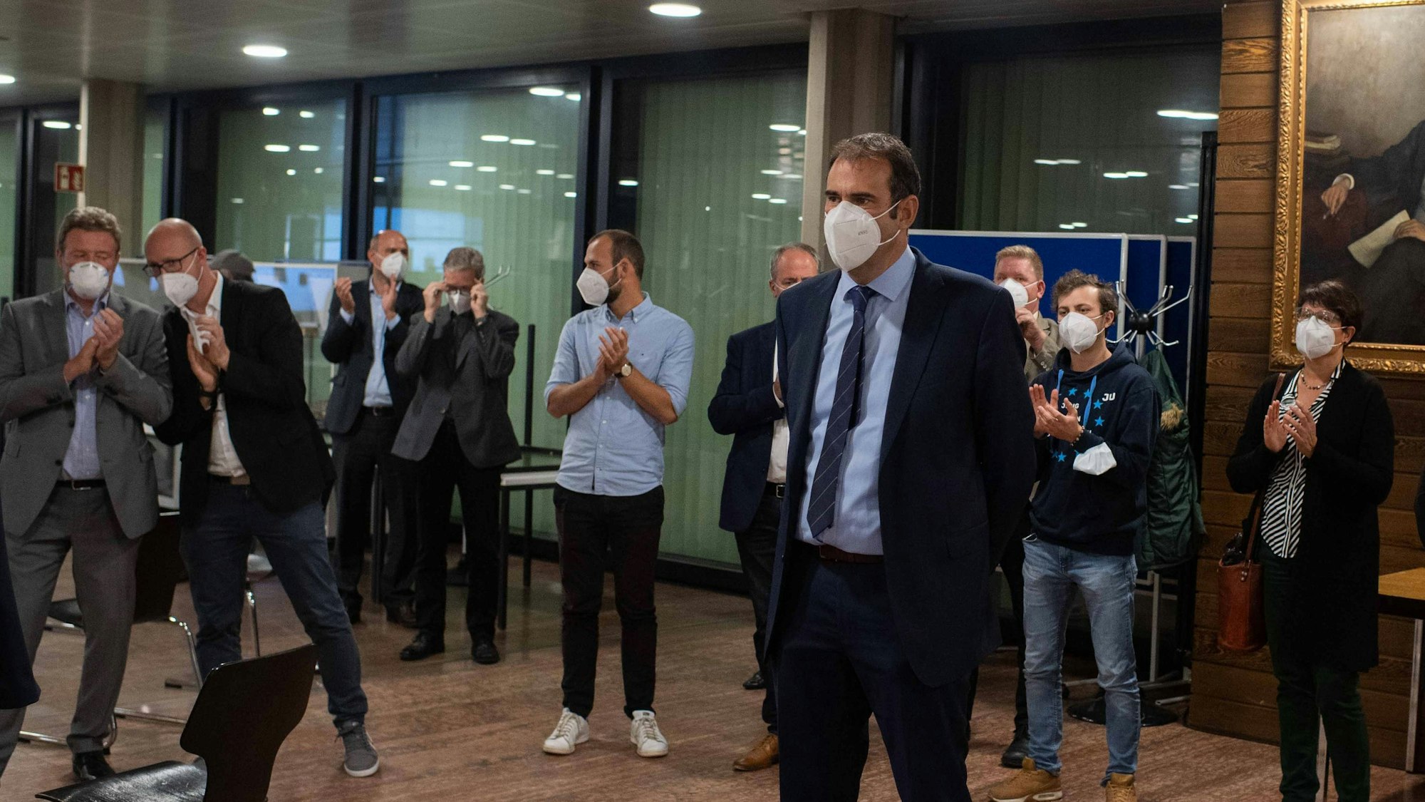 Das Bild zeigt eine Szene vom Wahlabend 2020. Johannes Winckler steht vorne, mehrere CDU-Mitglieder haben einen Halbkreis um ihn gebildet und applaudieren ihm. Alle tragen Corona-Schutzmasken.