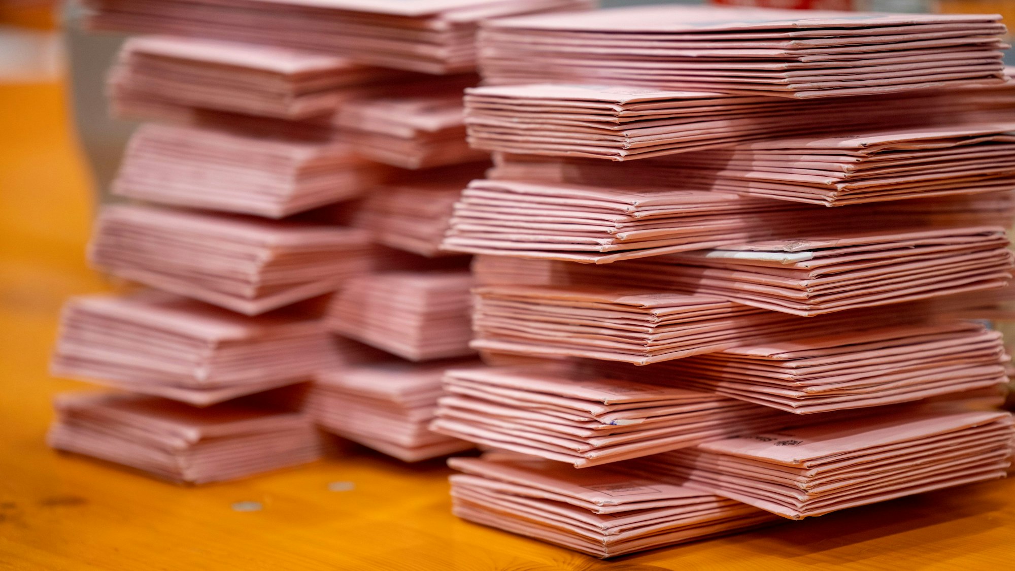 Auf zwei Stapeln liegen Briefwahlumschläge.