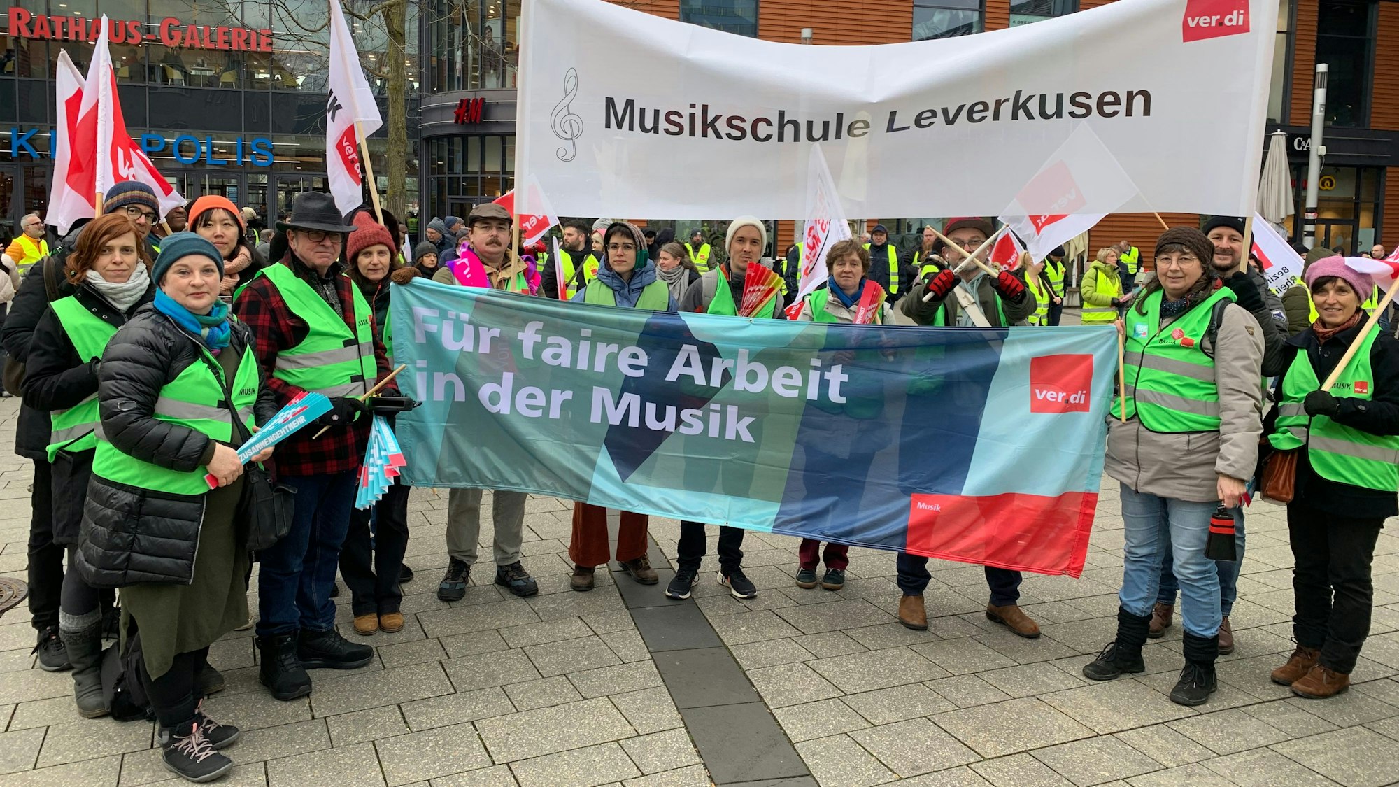 Streikende Menschen halten Banner und Plakate in den Händen.