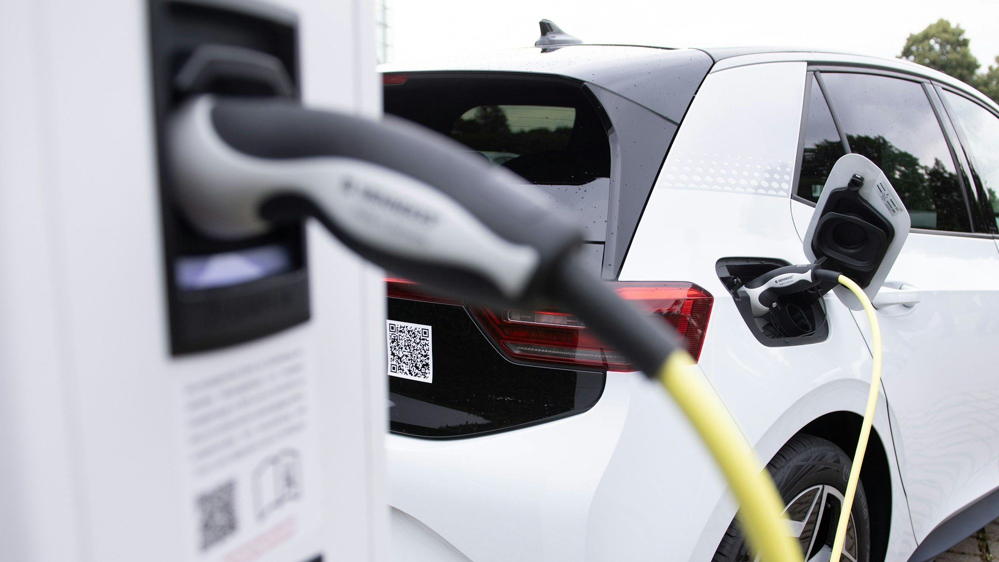 Ein weißes E-Auto an einer Ladestation.