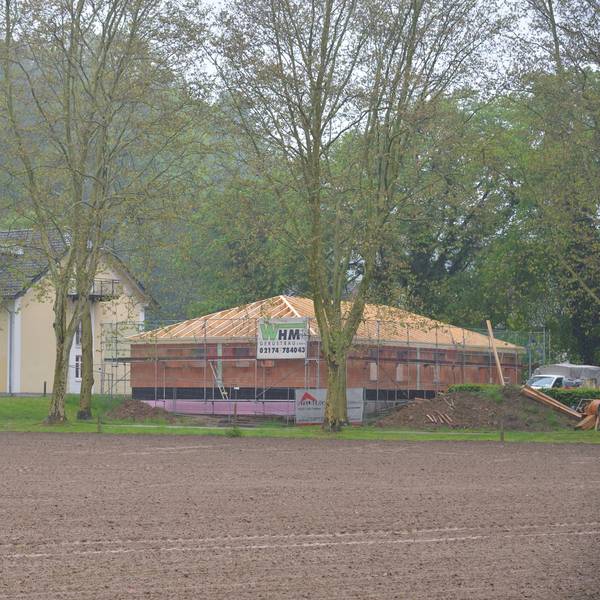 Ein gelbes Haus unter Linden.