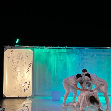 Mehrere Schauspieler agieren auf einer Bühne.