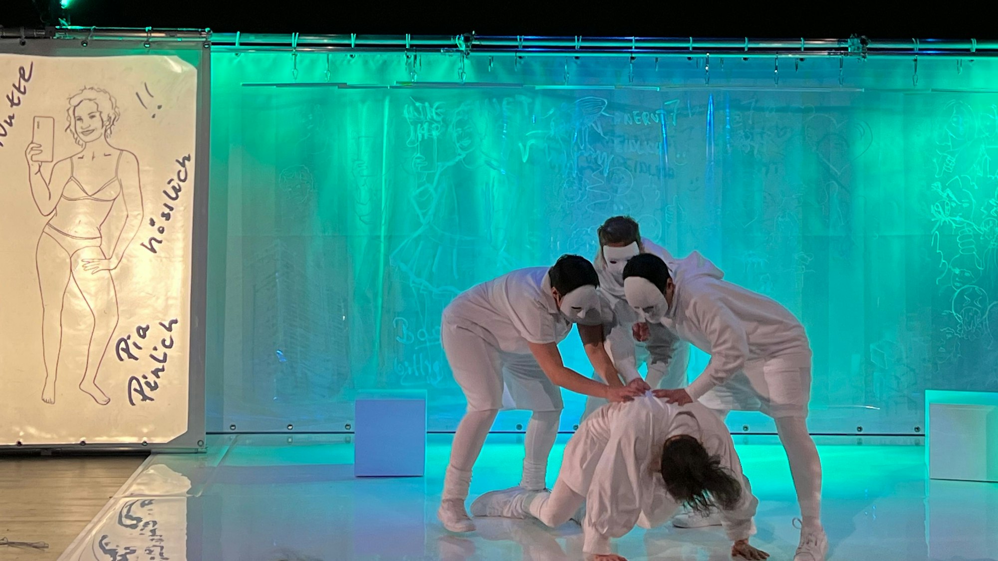 Mehrere Schauspieler agieren auf einer Bühne.