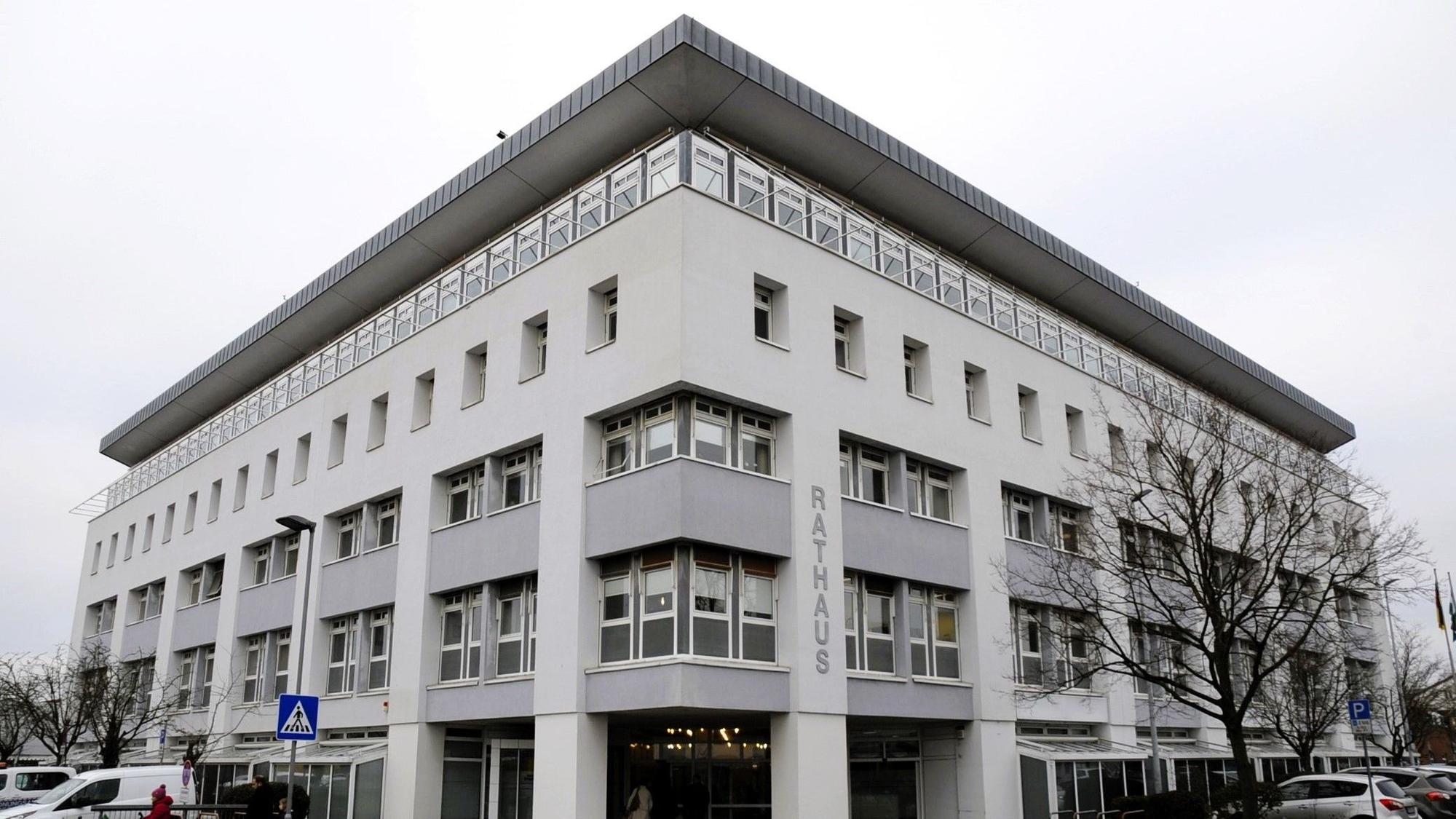 Zu sehen ist ein weißes Gebäude mit vier Etagen und der Aufschrift „Rathaus“.