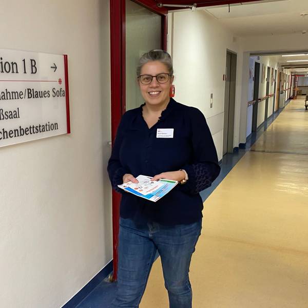 Lotsin Birgit Hellmann läuft den Flur der Wochenbettstation im Marien-Hospital Euskirchen entlang. In den Händen hält sie Infomaterial.