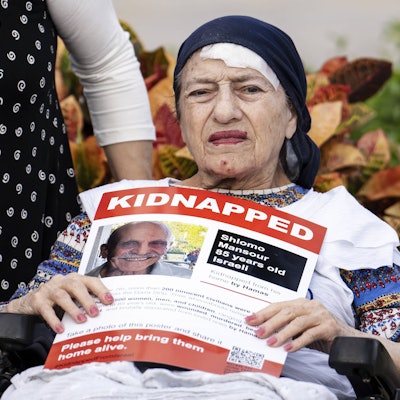 Eine alte Frau hält ein Bild des getöteten Schlomo Manzur.