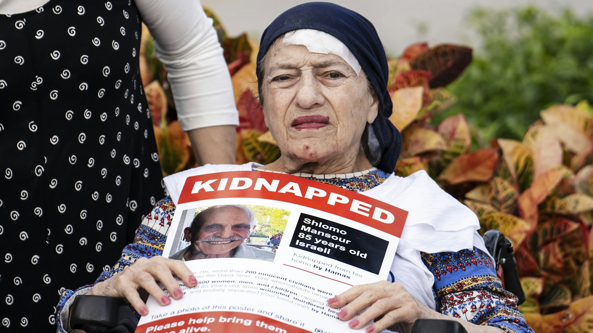 Eine alte Frau hält ein Bild des getöteten Schlomo Manzur.