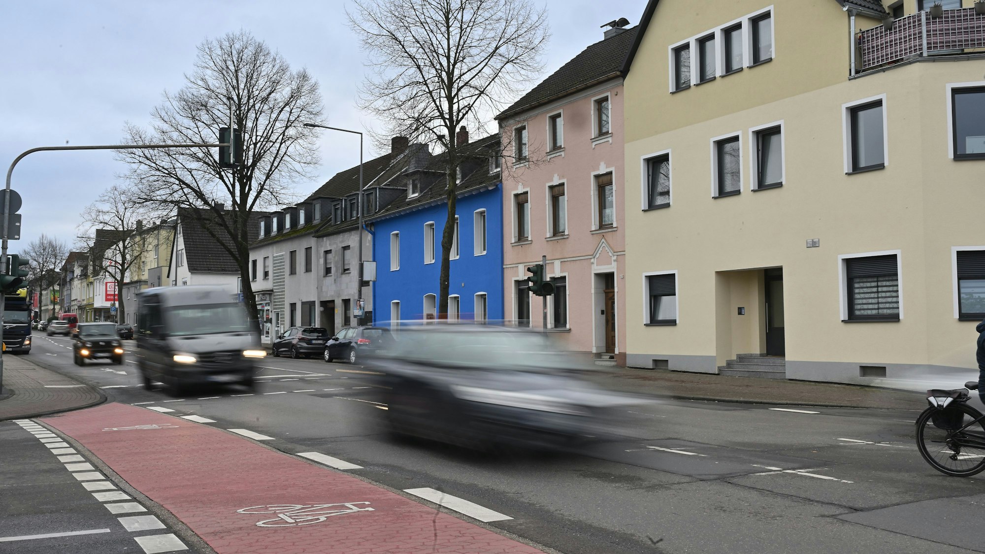 Auf der Straße sind außer Pkw, ein Fahrrad sowie ein Laster unterwegs.